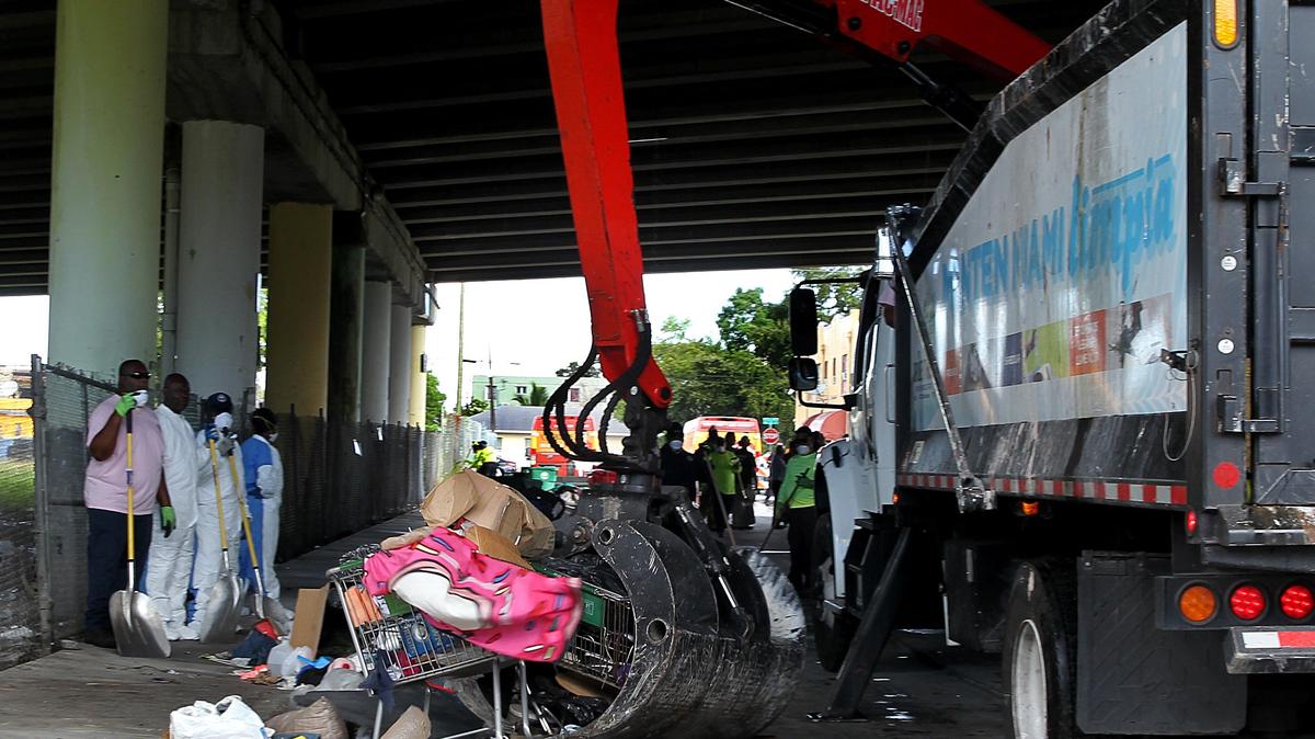 In a 2018 cleanup of streets under the Dolphin Expressway in Overtown, Miami sanitation workers picked up trash and discarded items left by homeless people.