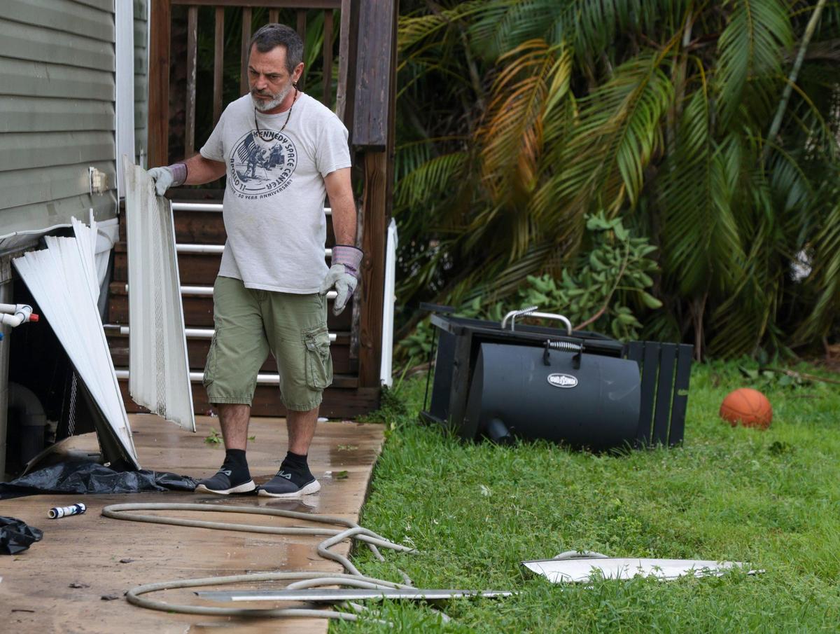 A resident of Sunshine Village removes debris after a tornado touch ground at the mobile home park. A tornado possibly spawned by Hurricane Ian caused downed trees, traffic lights, and damage to property in and around Sunshine Village, a mobile home park in Davie, Florida on Wednesday, September 28, 2022.