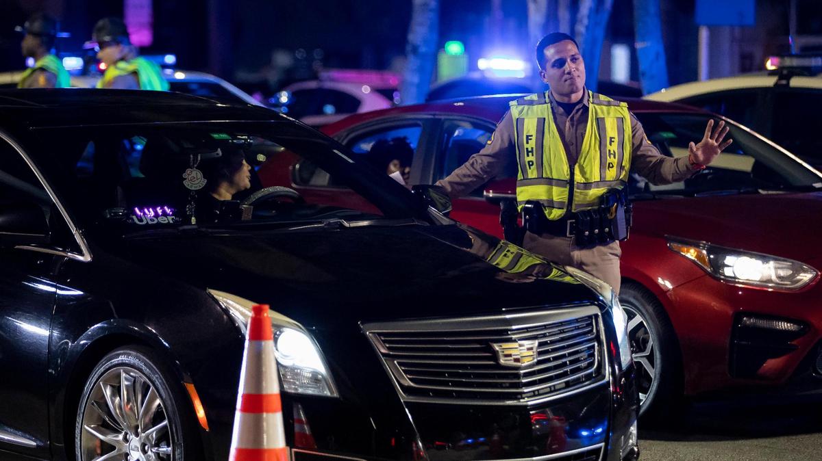 A Florida Highway Patrol officer talks with a driver at a checkpoint along Fifth Street on Friday, March 24, 2023, in Miami Beach, Fla.