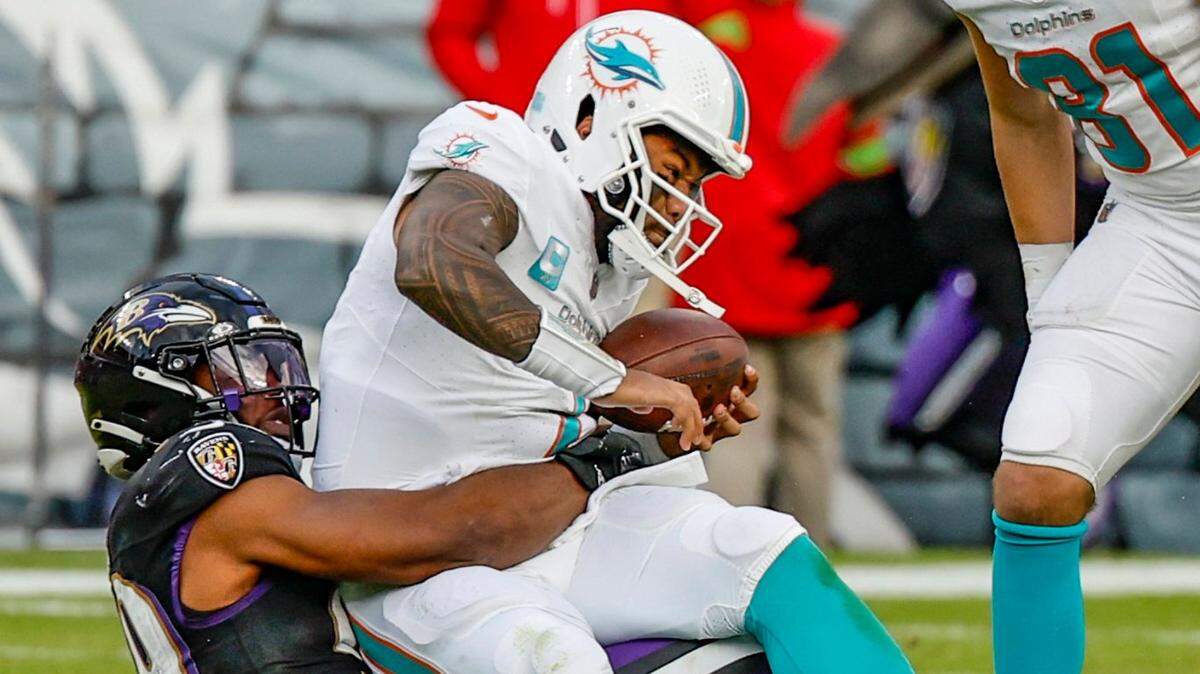 Miami Dolphins quarterback Tua Tagovailoa (1) is sacked by Baltimore Ravens linebacker Odafe Oweh (99) in the fourth quarter at M&T Bank Stadium in Baltimore, Maryland on Sunday, December 31, 2023.