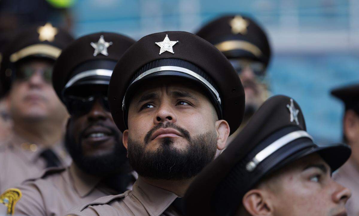 Officers from Miami-Dade Sheriff's Office attend a funeral service for Miami Beach Police Sergeant David Cajuso on Wednesday, Nov. 12, 2025, at the Hard Rock Stadium in Miami Gardens, Fla.