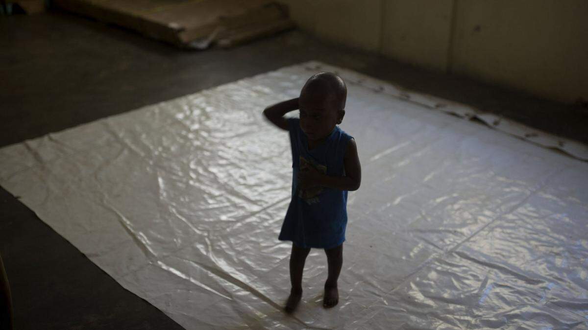 Children in Haitian orphanages, who have been adopted by families in the United States, are being blocked from leaving the country.