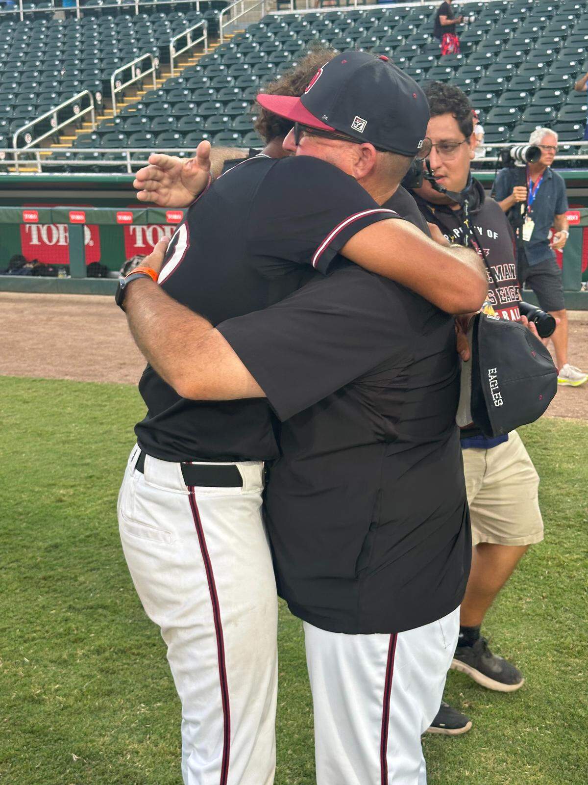 Stoneman Douglas pitcher Gio Rojas (left) hugs coach Todd Fitz-Gerald (right) on Saturday after beating Venice 2-1 on Saturday night to win the Class 7A state championship at Hammond Stadium in Fort Myers, Fla.