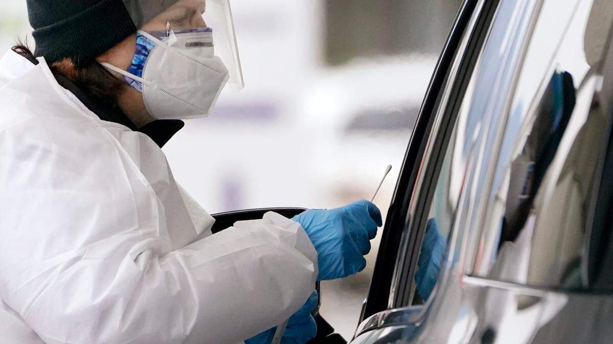 COVID-19 testing specialist Susana Blasco reaches forward with a swab to test a driver at a drive-up coronavirus testing location Tuesday, Dec. 21, 2021, in Bellingham, Wash. Washington health officials said Tuesday at least 400 cases of the new COVID-19 variant had been confirmed, but that omicron hasn’t yet overtaken delta cases in the state.