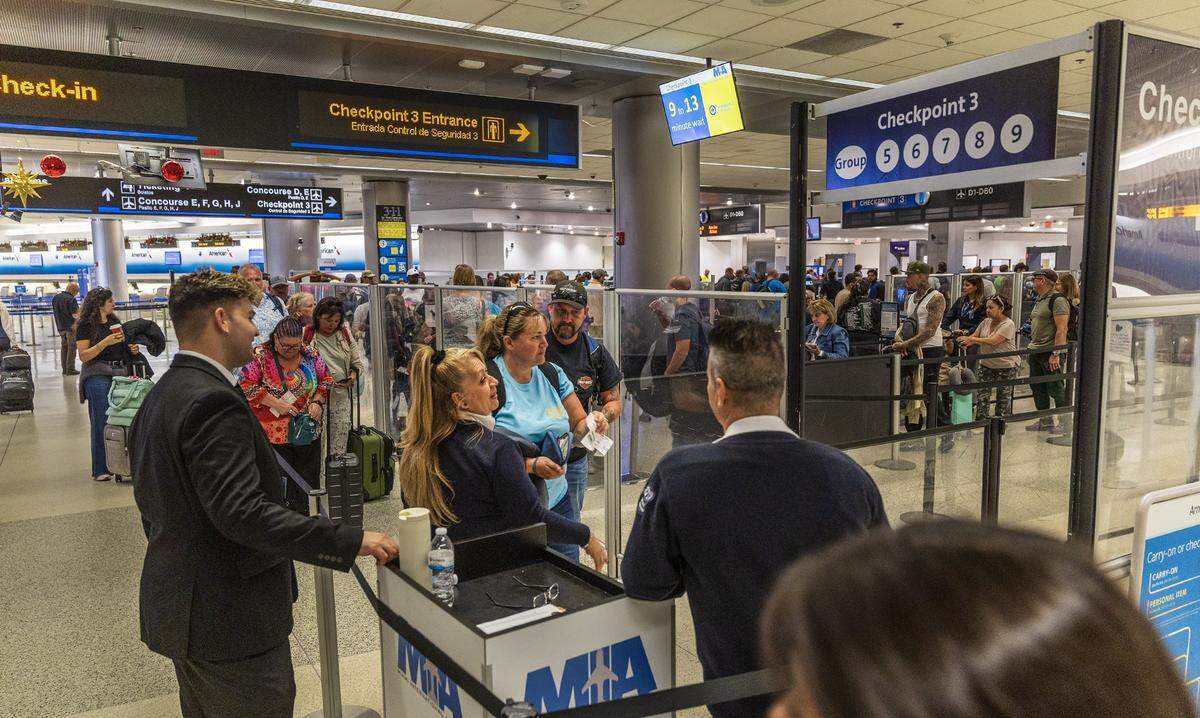 Employees guide passengers as they entered checkpoint three in Concourse D, at Miami International Airport ahead of the Holidays in Miami, on Friday, November 21, 2025.