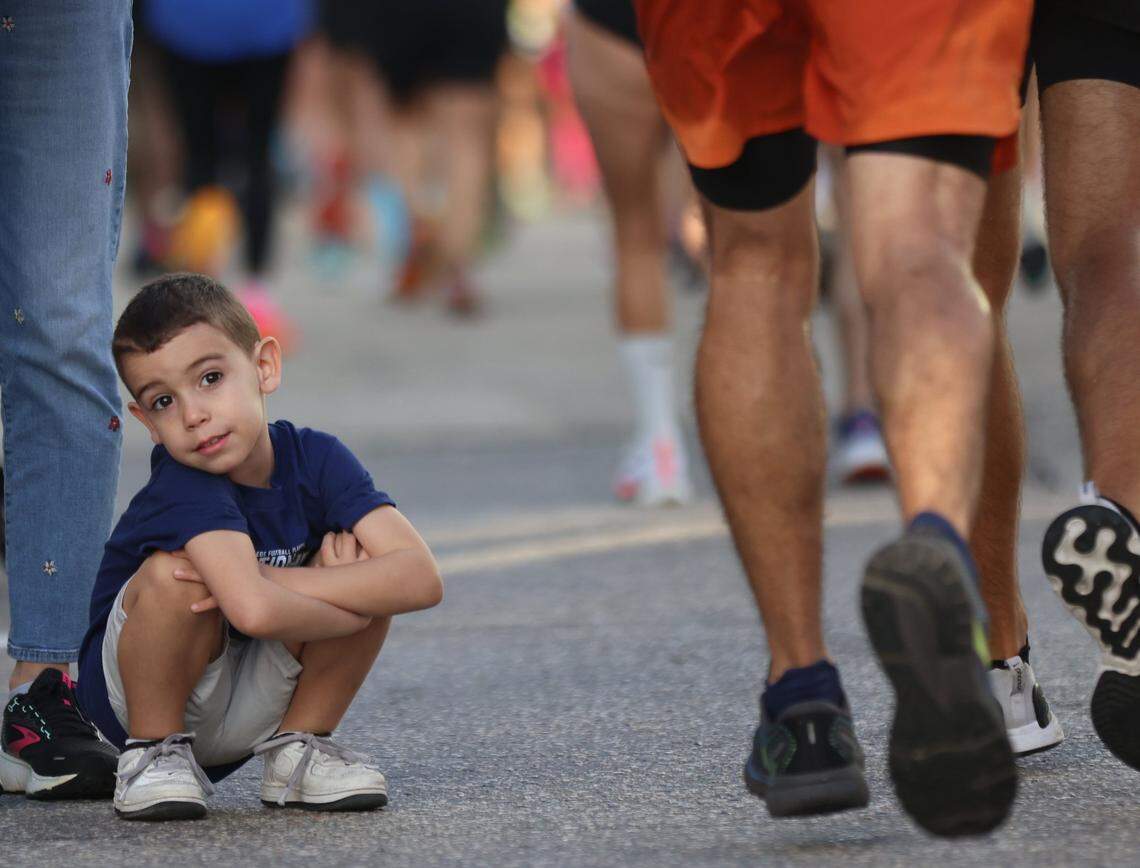 Asher Gonzalez, 3, waits patiently for the sight of his father and uncle at 11-mile of the Life Time Miami Marathon on Sunday, January 28, 2024 in Miami, Florida