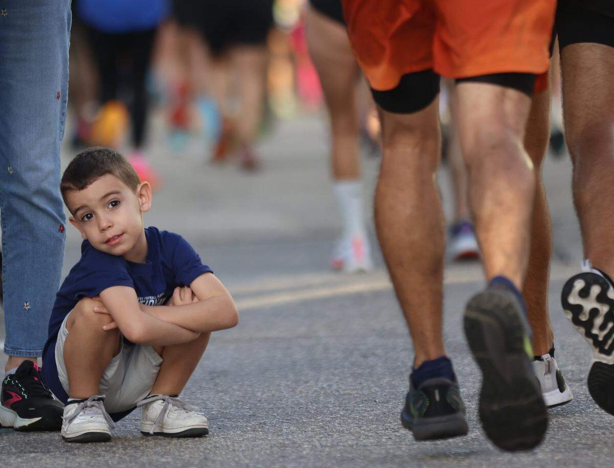 Asher Gonzalez, 3, waits patiently for the sight of his father and uncle at 11-mile of the Life Time Miami Marathon on Sunday, January 28, 2024 in Miami, Florida