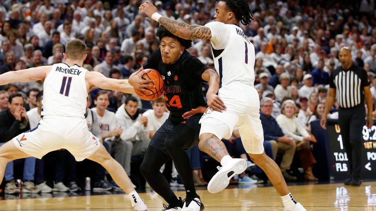 Feb 5, 2024; Charlottesville, Virginia, USA; Miami (Fl) Hurricanes guard Nijel Pack (24) controls the ball as Virginia Cavaliers guard Dante Harris (1) and Cavaliers guard Isaac McKneely (11) defend during the first half at John Paul Jones Arena. Mandatory Credit: Amber Searls-USA TODAY Sports