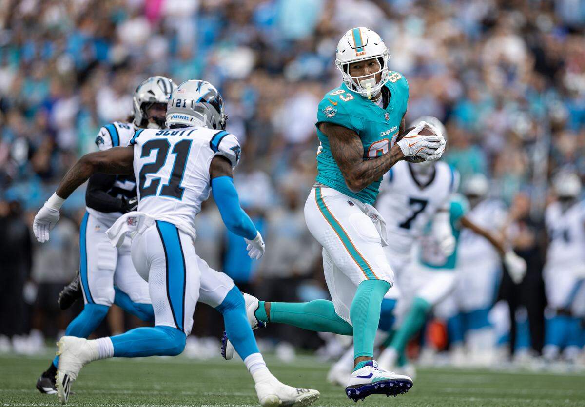 Miami Dolphins tight end Darren Waller (83) catches a pass as Carolina Panthers safety Nick Scott (21) defends during the first half of an NFL football game, Sunday, Oct. 5, 2025, in Charlotte, N.C.