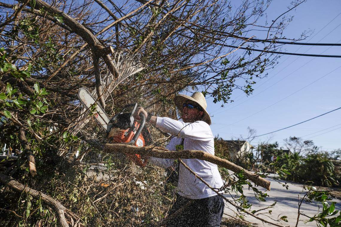 Brad Morris with Monroe  County Fire Rescue trims a fallen tree from a neighborhood in Cudjoe Key. The island community took a direct hit.