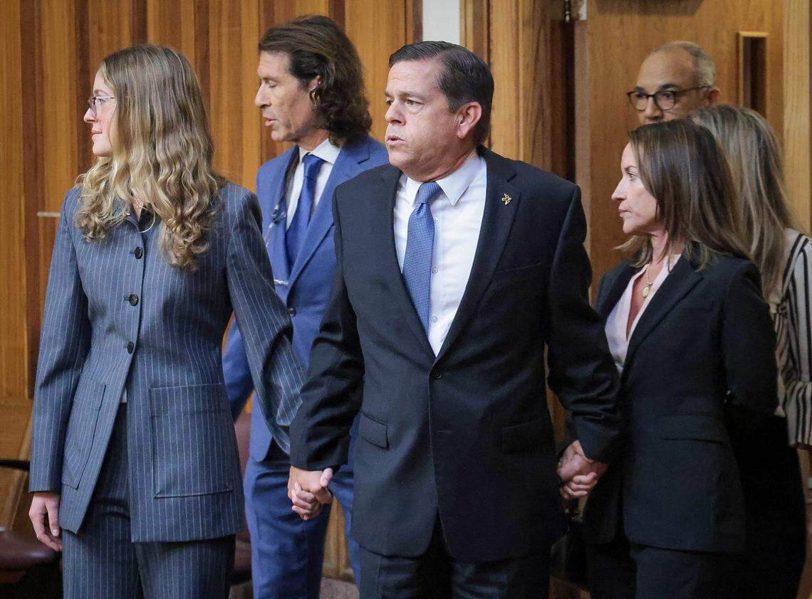Real estate broker George Pino, center, walks into a Miami-Dade courtroom holding the hands of his daughter, Carolina Pino, left, and wife, Cecilia Pino, right, on Nov. 21, 2024. Pino pleaded not guilty to felony vessel homicide in the 2022 Labor Day weekend boat crash that killed a 17-year-old girl and severely injured her classmate. Pino was piloting the boat when it crashed into a concrete channel marker in Biscayne Bay.