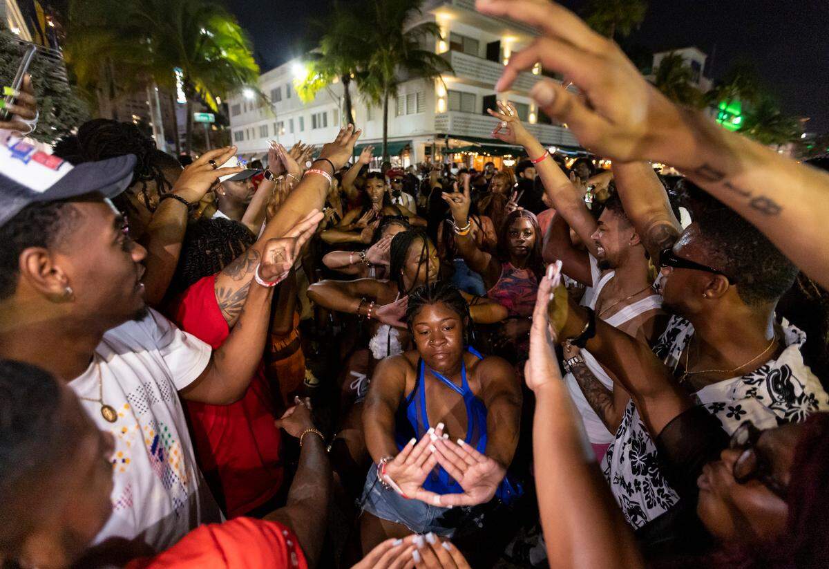 A crowd of people dance on Ocean Drive during spring break on Saturday, March 11, 2023, in Miami Beach, Fla.