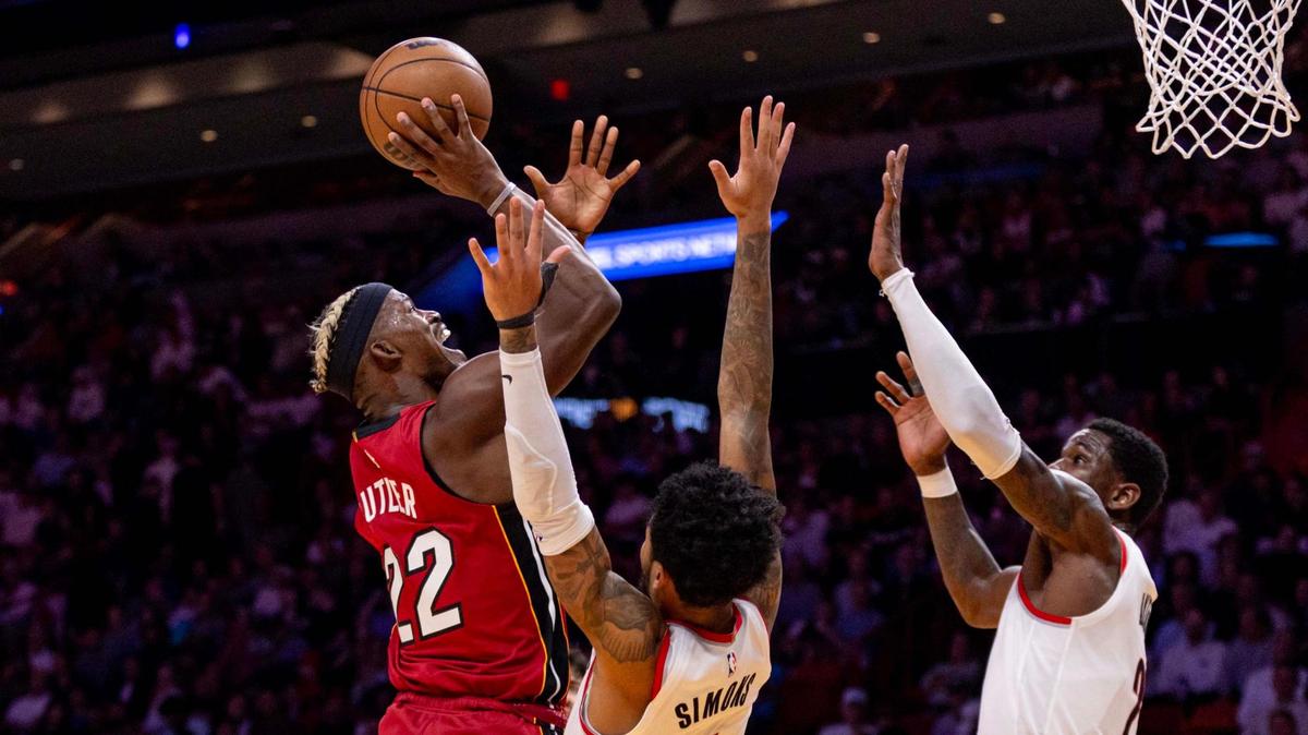 Miami Heat forward Jimmy Butler (22) attempts to score over Portland Trail Blazers guard Anfernee Simons (1) and center Deandre Ayton (2) during the second half of an NBA game at the Kaseya Center on Tuesday, January 21, 2025, in Miami, Fla.
