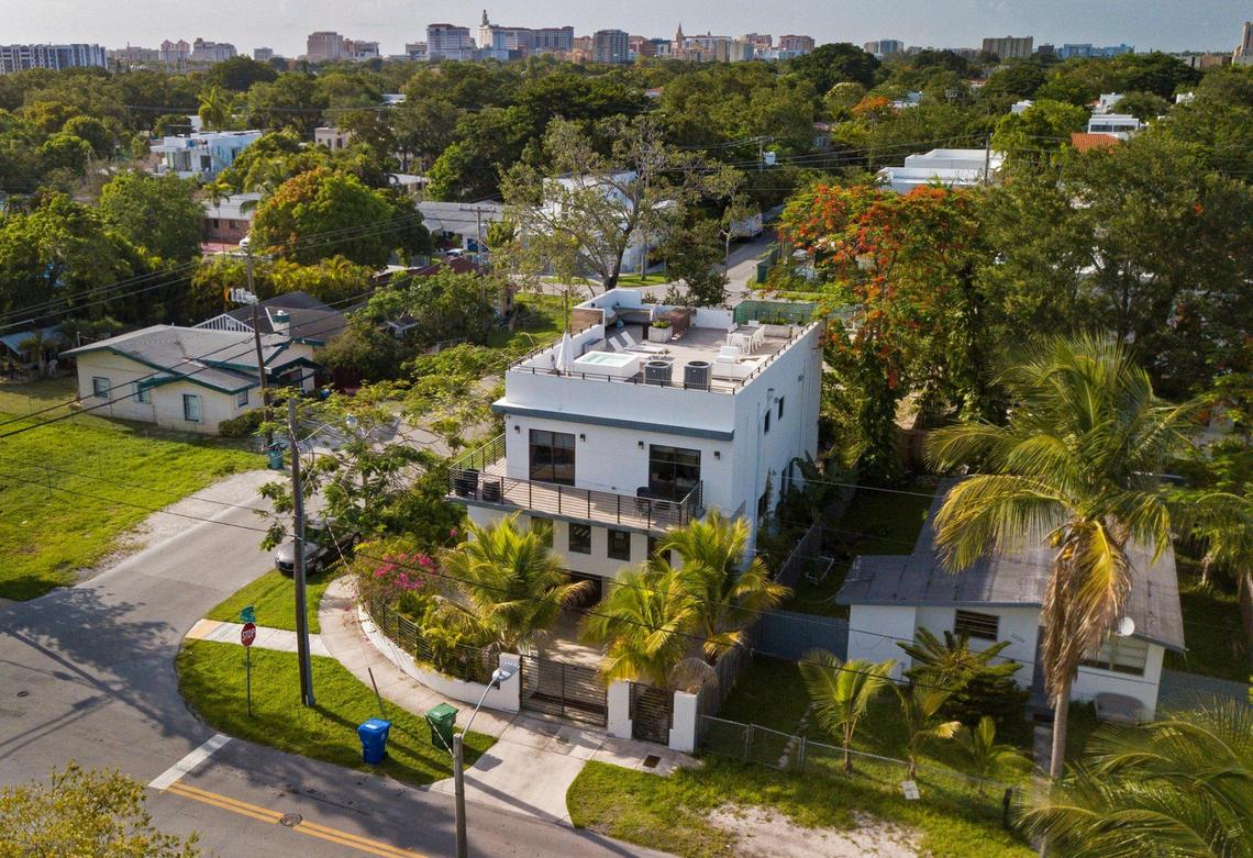 A luxury home with a rooftop deck looms over modest working-class homes at the corner of Elizabeth Street and Frow Avenue in Miami’s historically Black West Coconut Grove on Thursday, June 16, 2022.