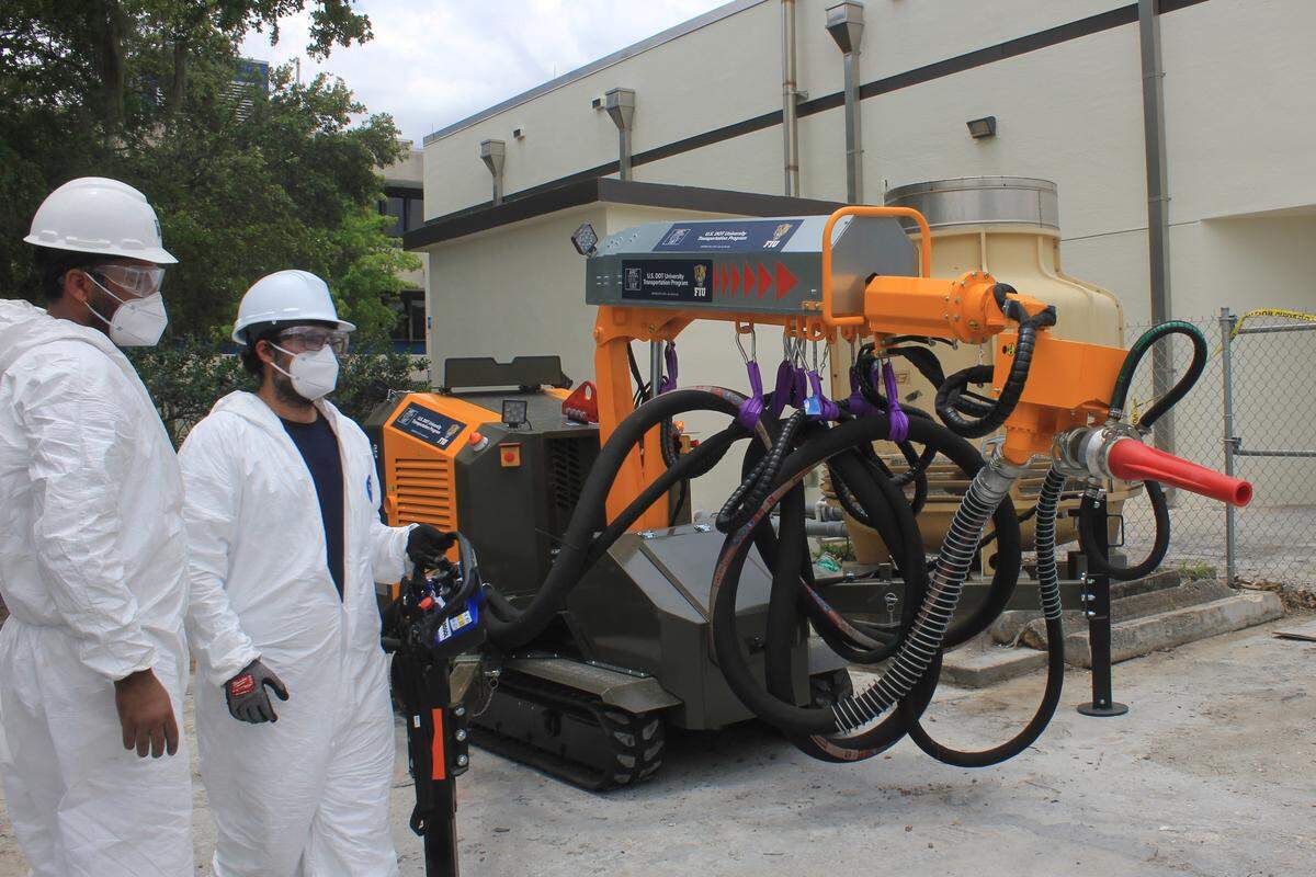 Researchers at Florida International University assist in the demonstration of a robot that can automate the use of Sprayable Ultra-High Performance Concrete at Florida International University’s engineering campus on May 29, 2026.