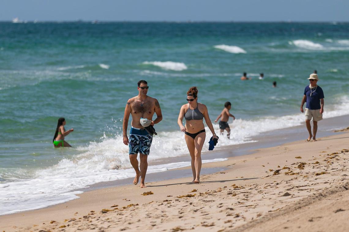 Chris Jablonski, 35 and Jane Garofalo, 37, walk down Las Olas Beach in Fort Lauderdale, Florida on Saturday, May 30, 2020.