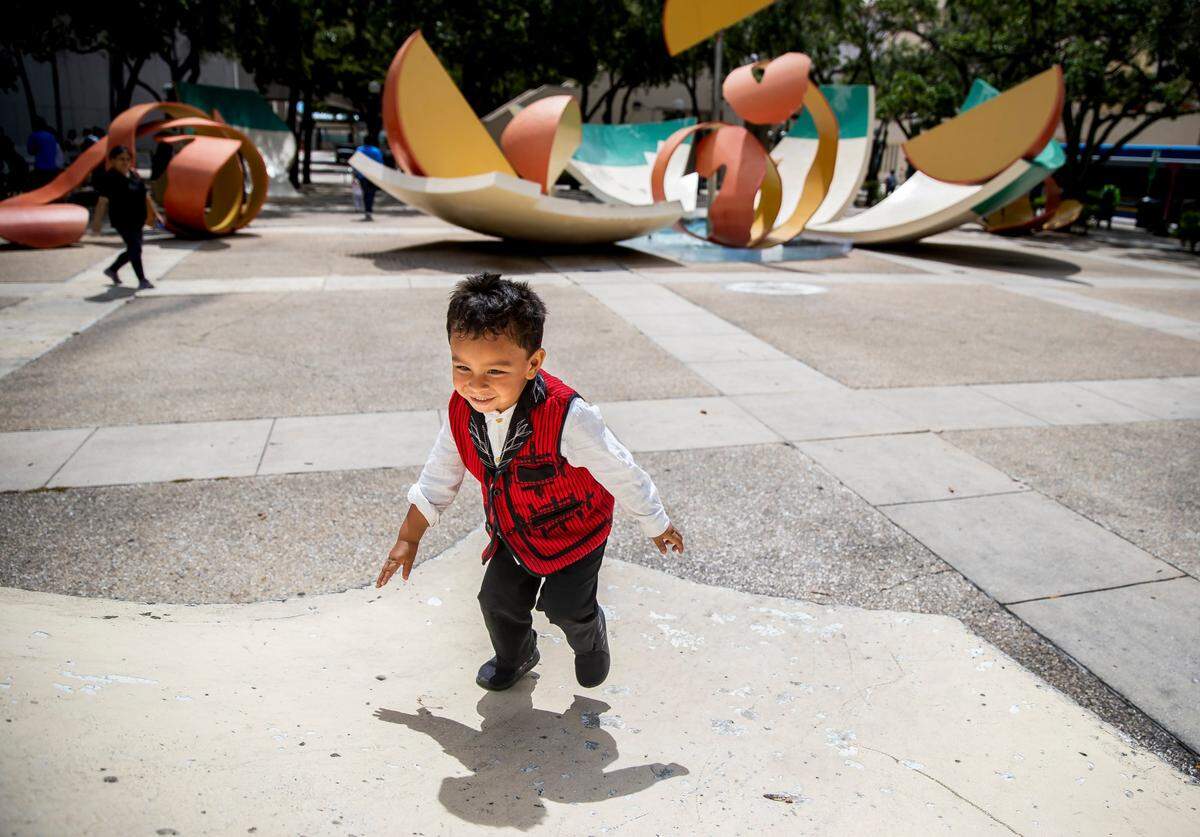 Alijah Hope, 3, plays on the Dropped Bowl with Scattered Slices and Peels art display outside of Government Center on Monday, May 15, 2023, in downtown Miami, Florida. Miami-Dade announced the start of the heat season and officials with the National Weather Service declared they would lower the threshold for heat warnings and advisories in the county.
