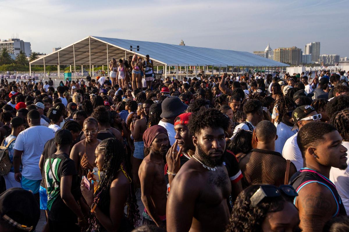 People stand in a crowd at South Beach during Spring Break in Miami Beach, Florida, on Saturday, March 18, 2023.