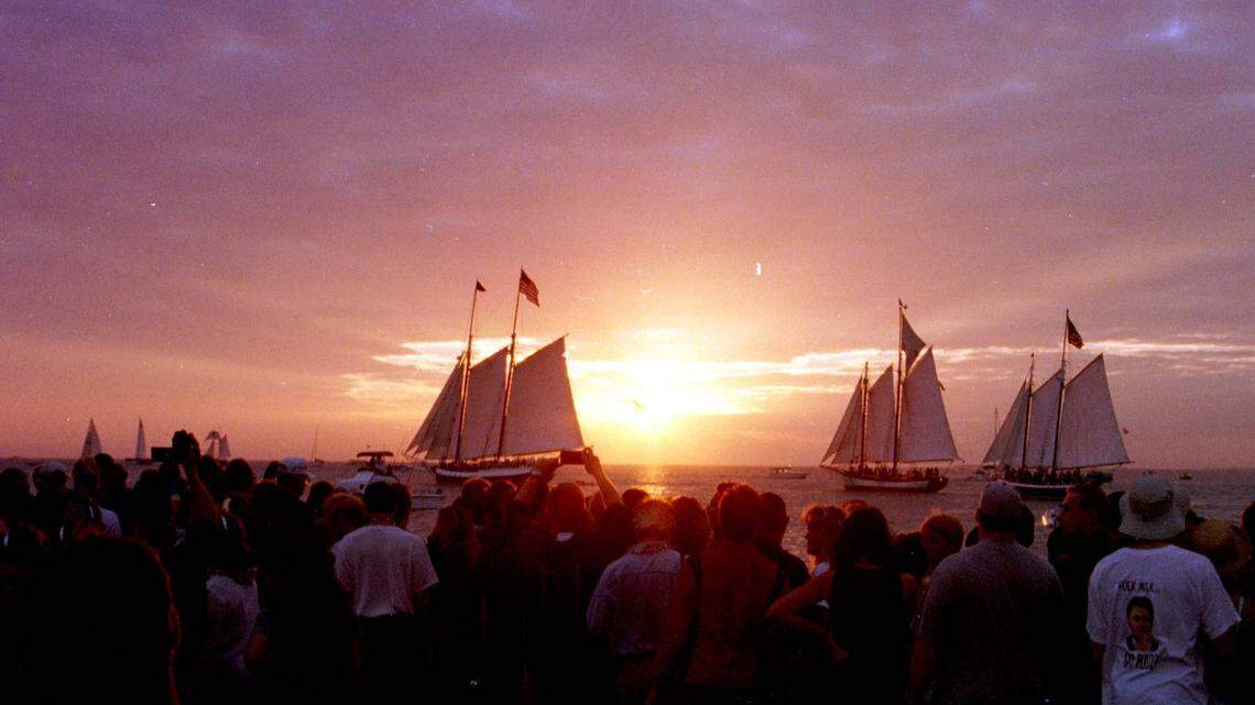 Key West’s schooner fleet glides past Mallory Square as a crowd gathered to watch the sun sink into the Gulf of Mexico. Crowds have gathered at Mallory for decades for the sunset celebration.