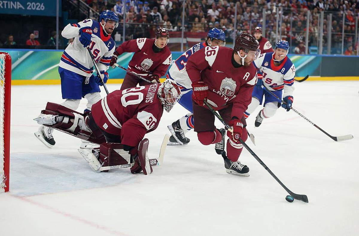 MILAN, ITALY - FEBRUARY 12: Uvis Balinskis #26 of Team Latvia controls the puck in the first period during the Men's Preliminary Group C match between Latvia and United States on day six of the Milano Cortina 2026 Winter Olympic games at Milano Santagiulia Ice Hockey Arena on February 12, 2026 in Milan, Italy. (Photo by Gregory Shamus/Getty Images)