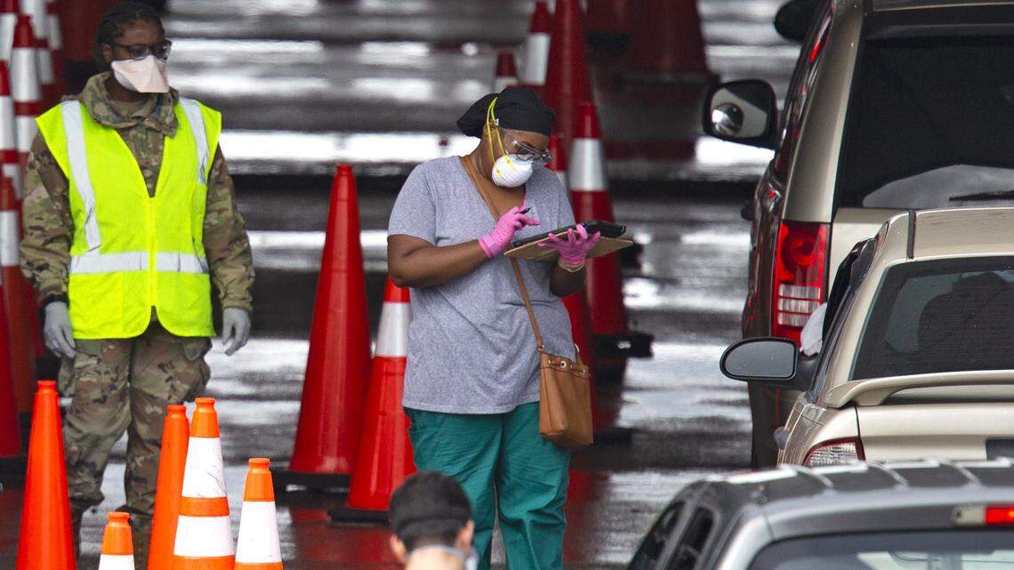 Vehicles line up as a healthcare workers help to check in people being tested at the COVID-19 drive-thru testing center at Hard Rock Stadium in Miami Gardens on Nov. 22. “With Florida recently entering Phase 3 of its COVID-19 reopening plan, and as more businesses reopen, employers may face a variety of issues with allowing employees to return to the workplace.”