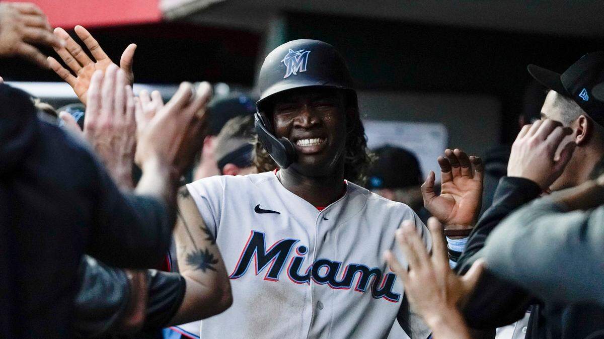 Miami Marlins’ Jesus Sanchez, center, celebrates with teammates after scoring on a single by Jorge Alfaro during the fourth inning of a baseball game against the Cincinnati Reds on Thursday, Aug. 19, 2021, in Cincinnati.