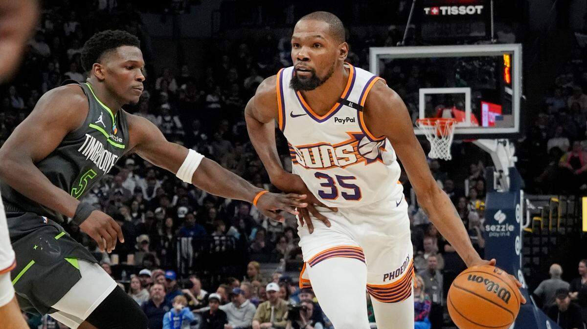 Phoenix Suns forward Kevin Durant (35) brings the ball up as Minnesota Timberwolves guard Anthony Edwards (5) defends him in the fourth quarter at Target Center.