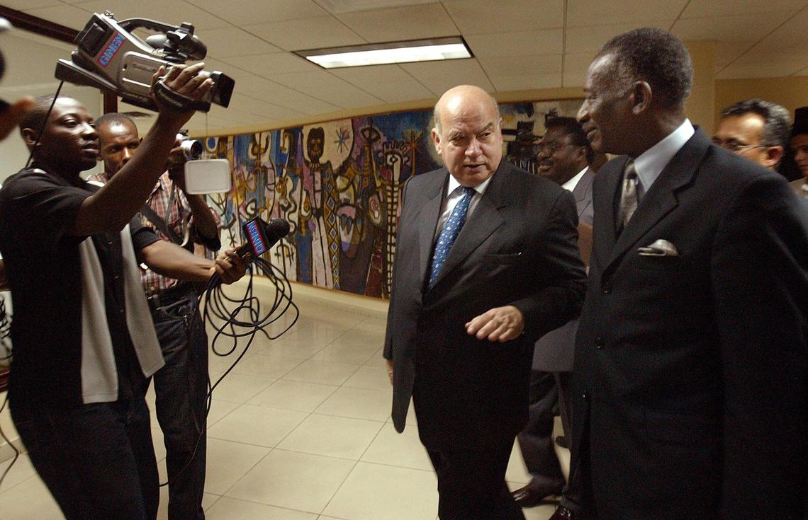 Jose Miguel Insulza, Secretary General of the Organization of American States (OAS), center, and Haiti’s Foreign Minister Hérard Abraham chat after his arrival at the airport in Port-au-Prince, Haiti, on July 5, 2005.