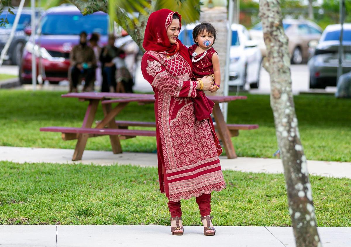 Sarah Siddiqui holds her daughter, Leeyana Sayeed, 1, as they attend the Eid al-Adha prayer ceremony at the Islamic Center of Greater Miami on Saturday, July 9, 2022, in Miami Gardens, Fla.