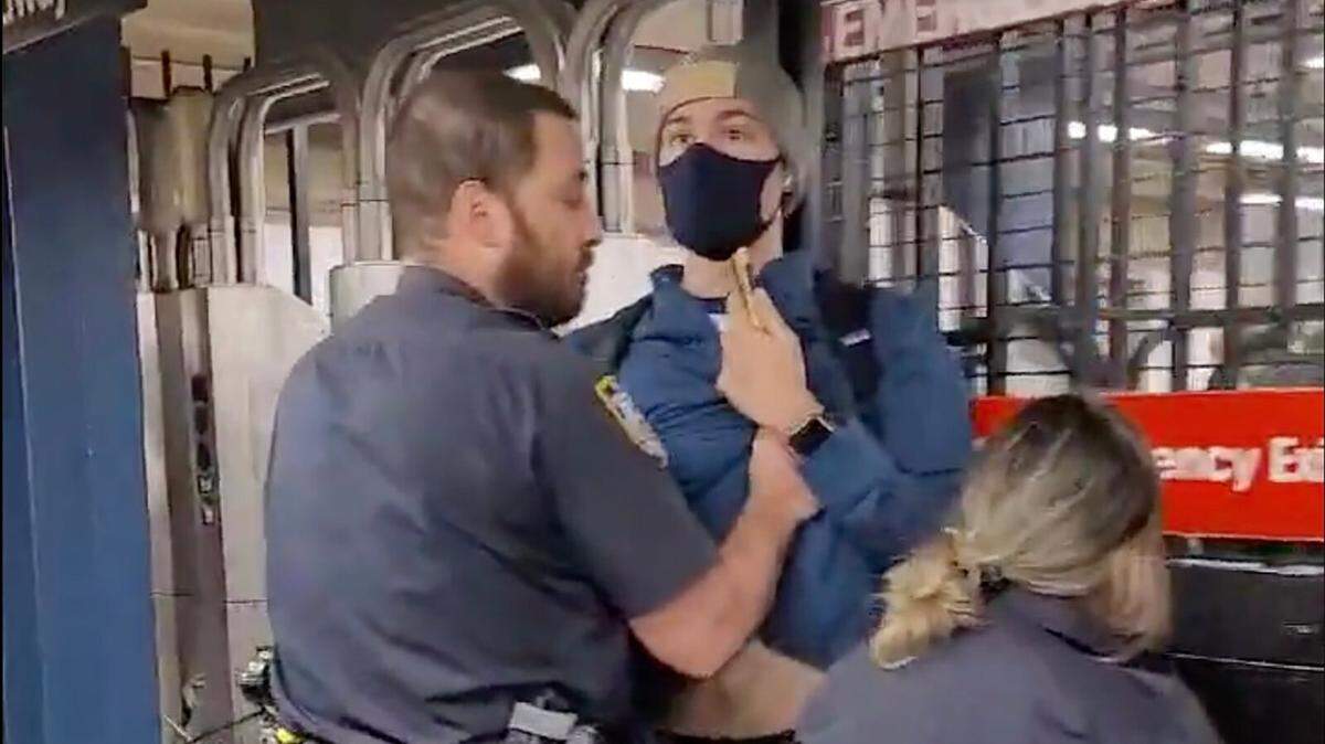 Two New York City officers shove a man off a subway platform after he questioned them about not wearing masks.