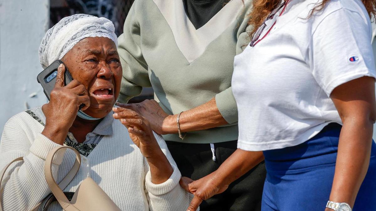 Francilia Jean recibe consuelo mientras un incendio envuelve su edificio de condominios de dos plantas en 395 NW 177 Street la mañana del sábado 28 de enero de 2023.