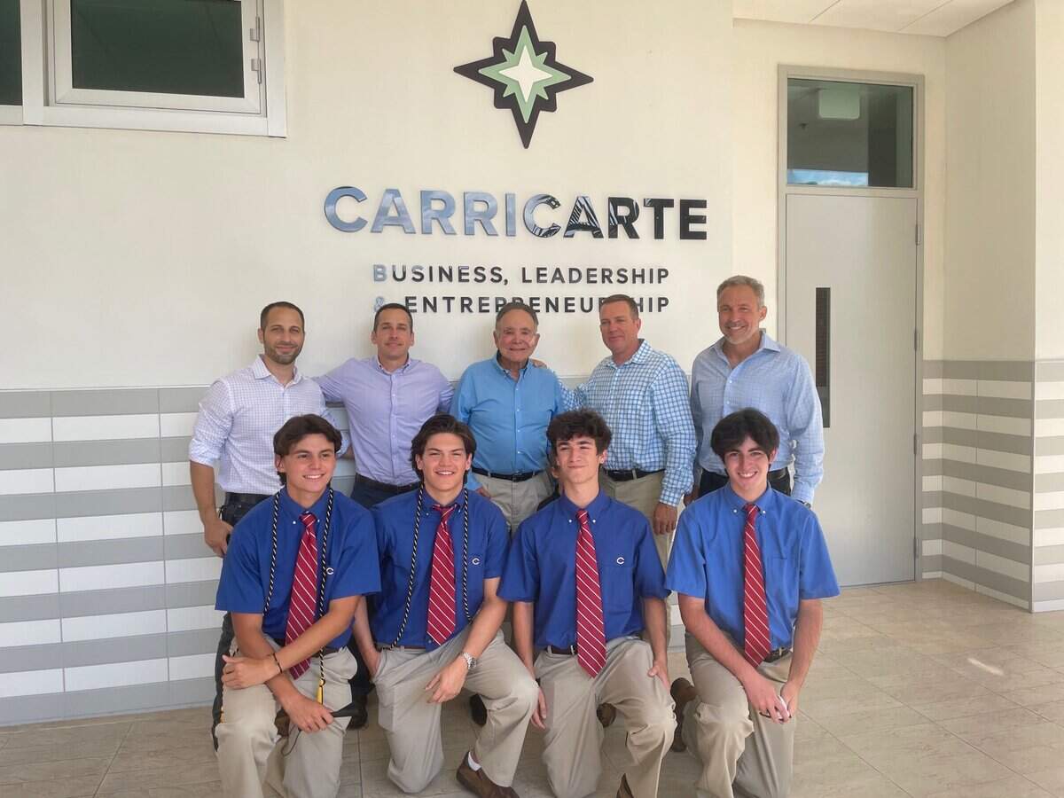 Members of the Carricarte family, back row, with Columbus High business students at the event on April 15, 2021, at which the new business program was unveiled. From left: Brian Carricarte, Andrew Carricarte, Mike Carricarte Sr., Louis Carricarte and Michael Carricarte Jr.