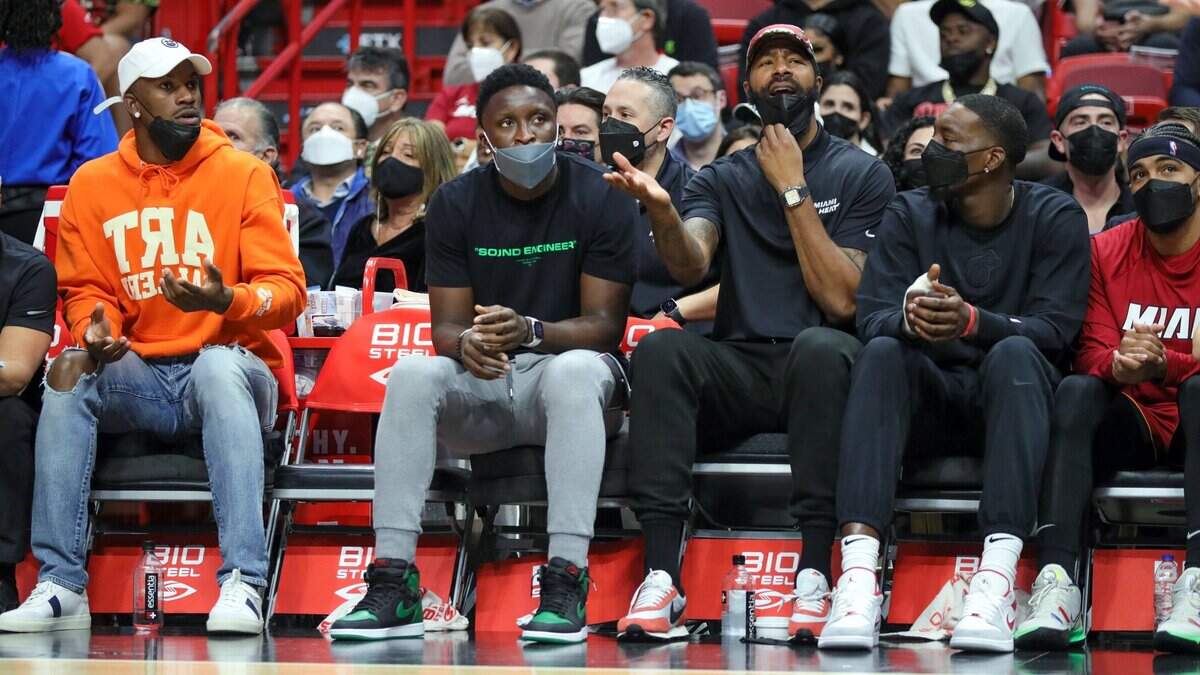 Los jugadores del Heat Victor Oladipo (2do izq.) y Markieff Morris (3do izq.) ven el juego contra Detroit junto a Jimmy Butler (izq), Bam Adebayo y Gabe Vincent (der,) el 23 de diciembre de 2021 en el FTX Arena.