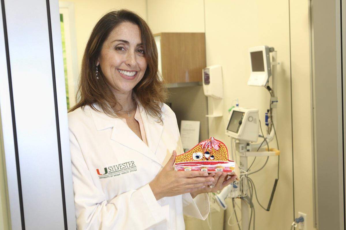 In this file photo from September 2016, Talia Donenberg, a certified genetic counselor who specializes in oncology at the Sylvester Comprehensive Cancer Center, part of UHealth, the University of Miami Health System, holds a model of a breast used to explain to patients how their procedures will work.