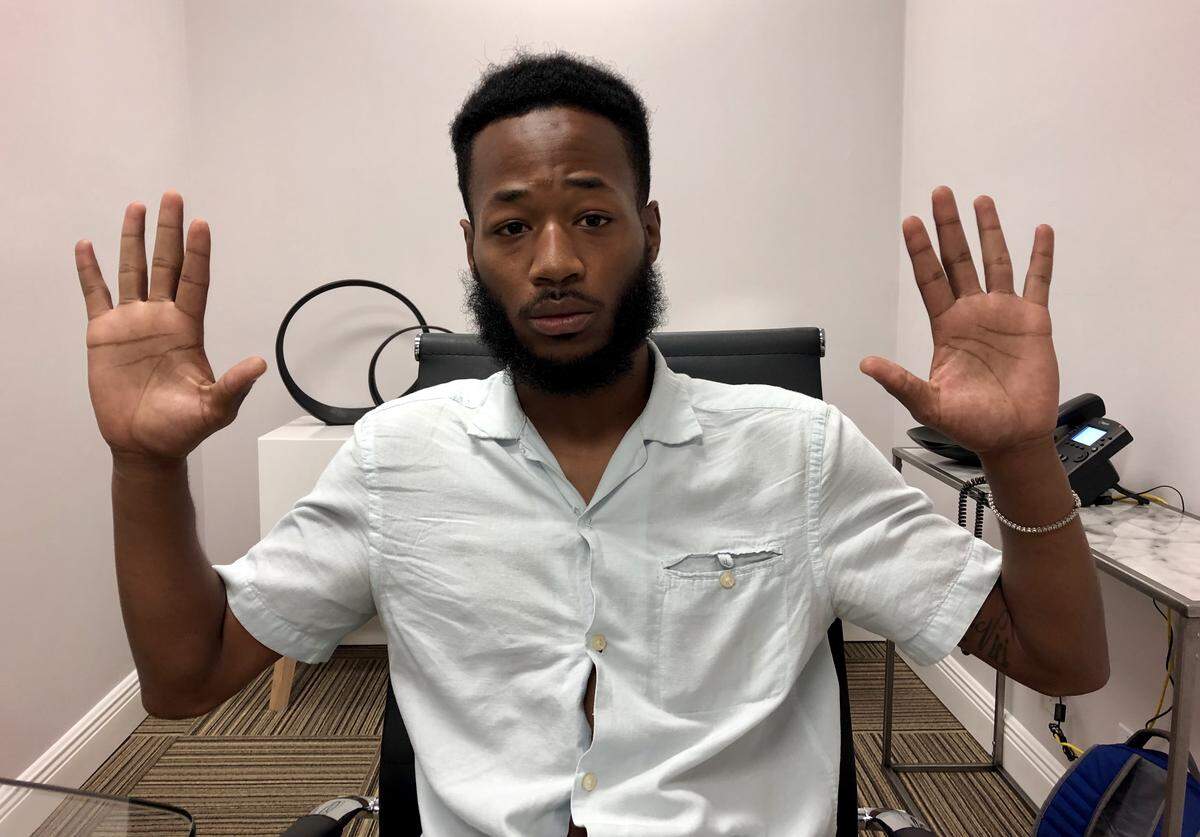 Steven Payne, a 26-year-old working on a PHD in sports management, shows how he held up his hands when a Miami-Dade police officer approched him on Nov. 1, 2017.