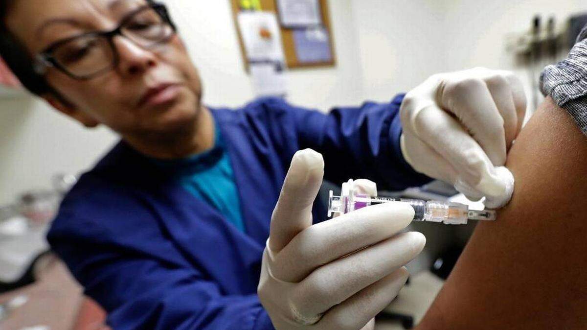 A health care practitioner delivers the flu vaccine to a patient. The 2018-19 flu season begins in October 2018 but the time to get your shot is now.
