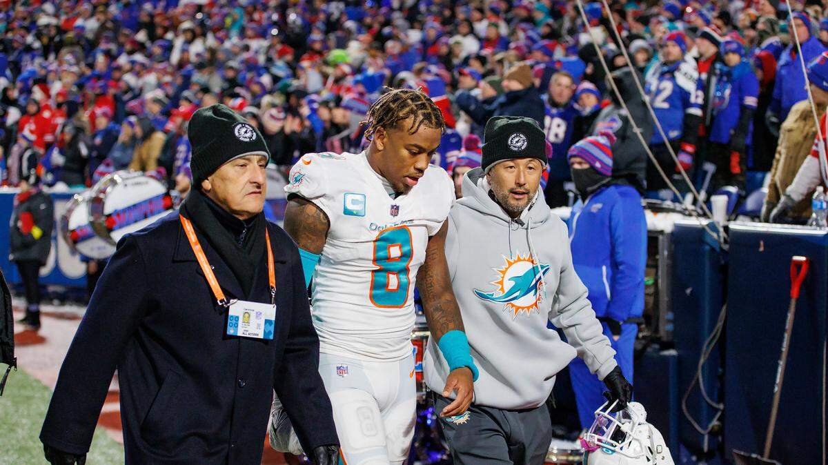 Miami Dolphins safety Jevon Holland (8) walks off the field with team team doctor John Uribe and associate athletic trainer Naohisa Inoue during second quarter of an NFL football game against the Buffalo Bills at Highmark Stadium on Saturday, December 17, 2022 in Orchard Park, New York.