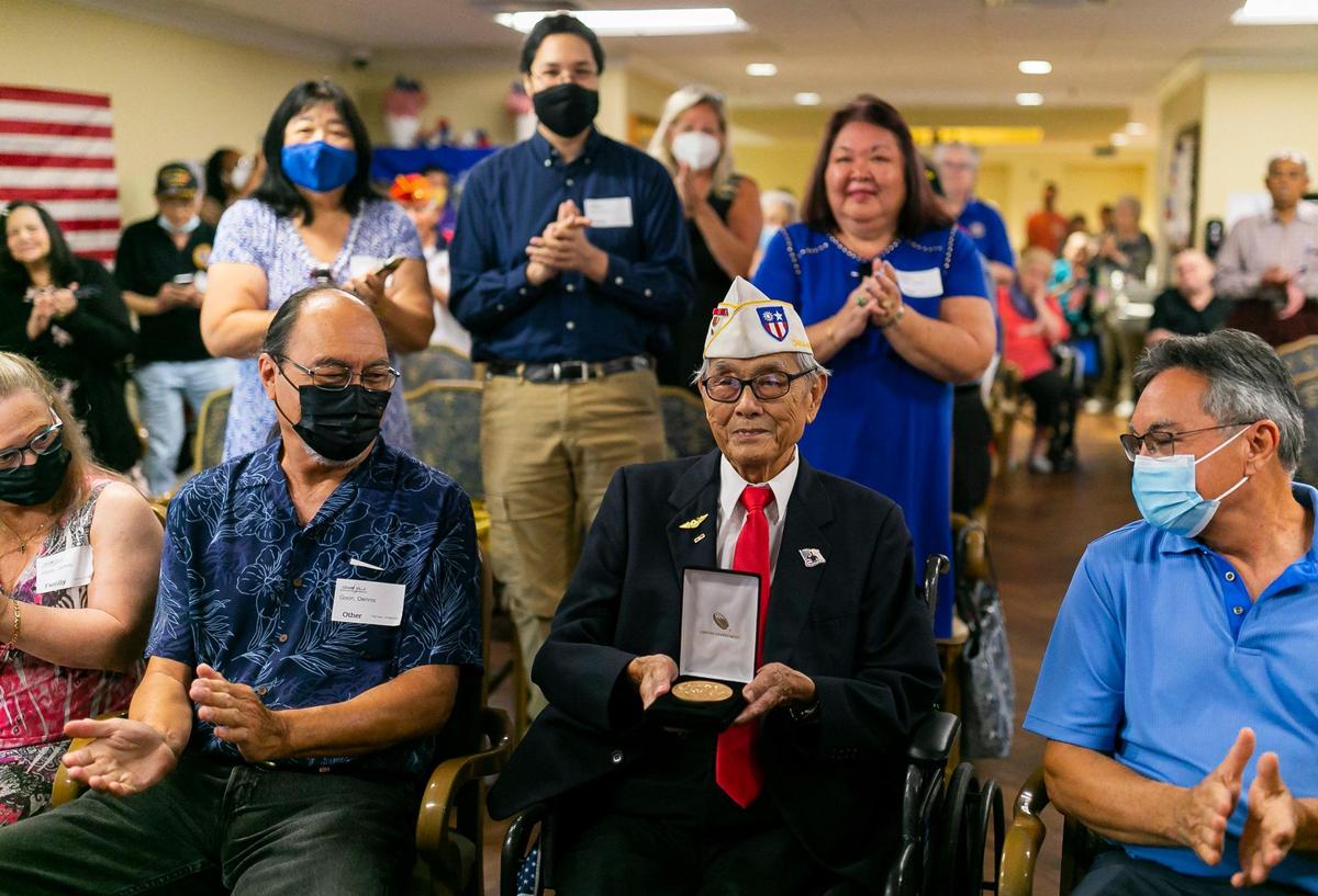 El veterano del Ejército de Estados Unidos Richard Goon, de 98 años, en el centro, es felicitado mientras sostiene la Medalla de Oro del Congreso durante una ceremonia virtual en la Grand Villa Senior Living Community el martes 5 de julio de 2022 en Deerfield Beach, Florida. Durante su servicio, Goon se capacitó como criptógrafo y finalmente fue destinado a la frontera entre China e Indochina, donde ayudó al ejército chino a luchar contra las fuerzas japonesas.