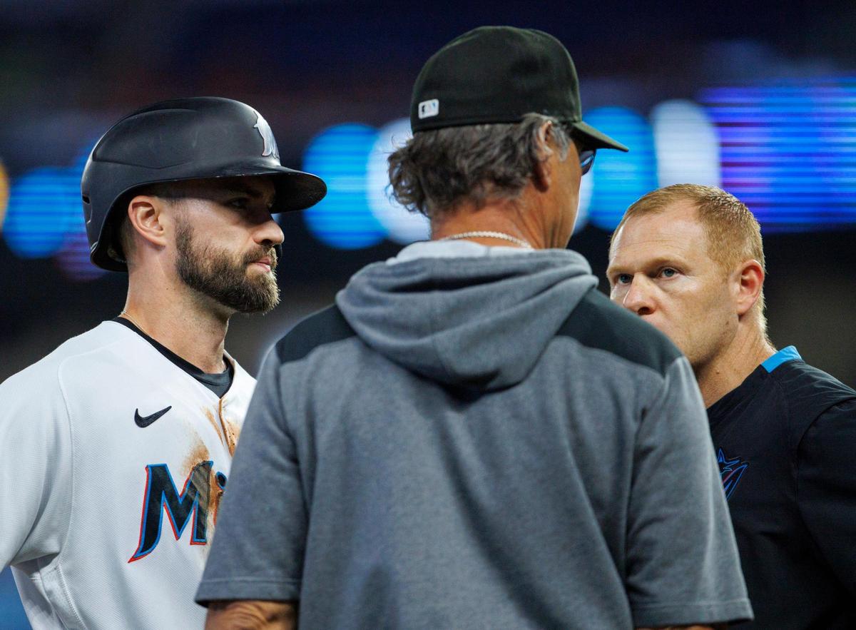 Miami Marlins manager Don Mattingly (8) and Marlins head athletic trainer Lee Meyer talk with Marlins second baseman Jon Berti (5) after he injured during the first inning of a baseball game against the Pittsburgh Pirates at LoanDepot Park on Thursday, July 14, 2022 in Miami, Florida.