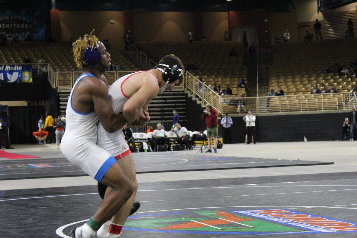 South Dade’s Joshua Swan (left) tries to take down Sawyer Bartelt of Doral Academy in the 152s final. Swan avenged last week’s triple overtime loss to Bartelt in the regional finals by winning 7-2 to capture his first state title.