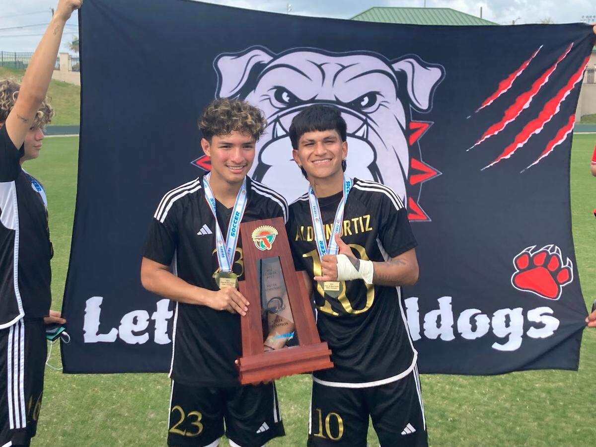 South Broward’s William Perdomo (left) and Aldrin Ortiz (right) pose with the state championship trophy on Saturday after a 1-0 overtime win over Viera at Spec Martin Stadium in DeLand, Fla.