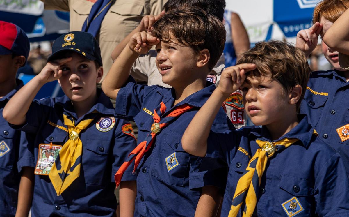 Members of Cub Scout Troop 65 salute while reciting the Pledge of Allegiance after marching down Ocean Drive during the 14th Annual Veterans Day Parade hosted by the city of Miami Beach. The parade took place Friday on Ocean Drive, from Fifth to 15th streets.