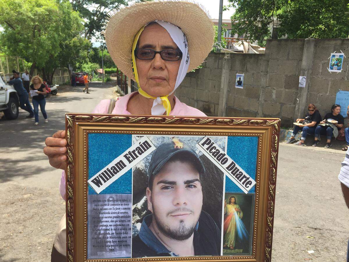 Corina Duarte Molina holds a photo of her nephew William Efraín Picado Duarte outside Managua's El Chipote jail as she waits for information.