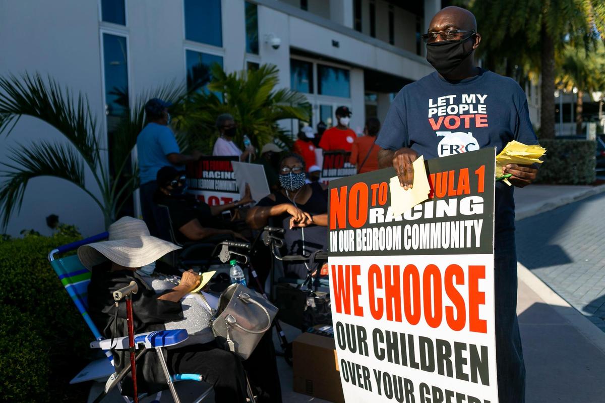 Francis Ragoo, right, participates in a protest against Formula One racing outside Miami Gardens City Hall on April 14, 2021.