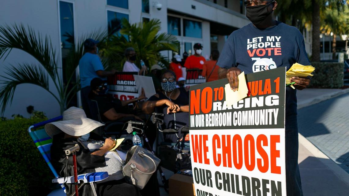Francis Ragoo, right, participates in a protest outside of the Shirley M. Gibson City Hall in Miami Gardens, Florida, on Wednesday, April 14, 2021. Activists gathered in opposition of bringing Formula One racing to Hard Rock Stadium in Miami Gardens.