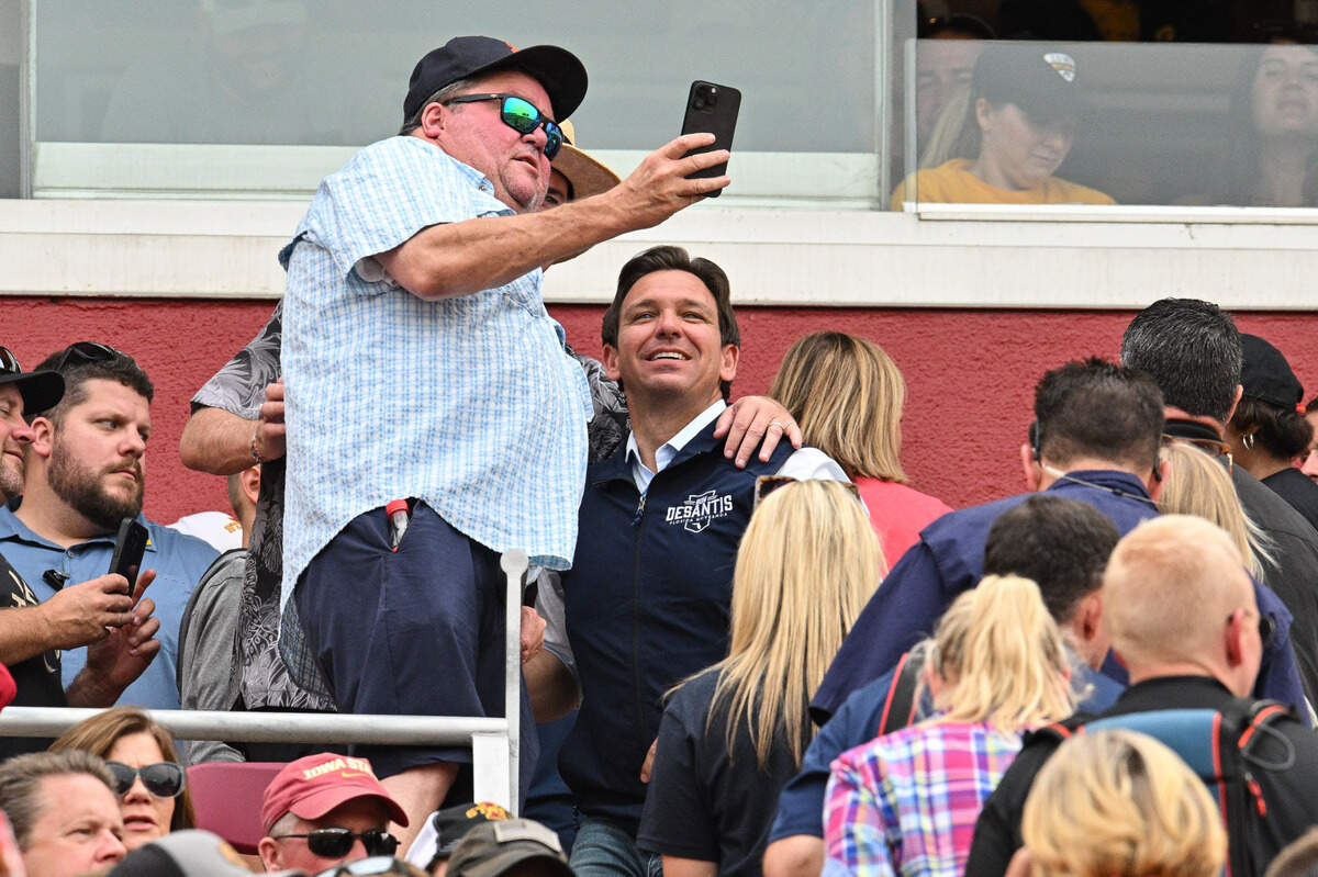 Florida Gov. Ron DeSantis takes a photo with a supporter while attending the game between the Iowa State Cyclones and the Iowa Hawkeyes in Ames, on Sept. 9. 