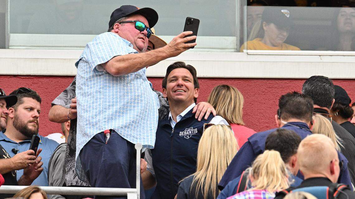 Florida Gov. Ron DeSantis takes a photo with a supporter while attending the game between the Iowa State Cyclones and the Iowa Hawkeyes in Ames, Iowa, on Sept. 9.