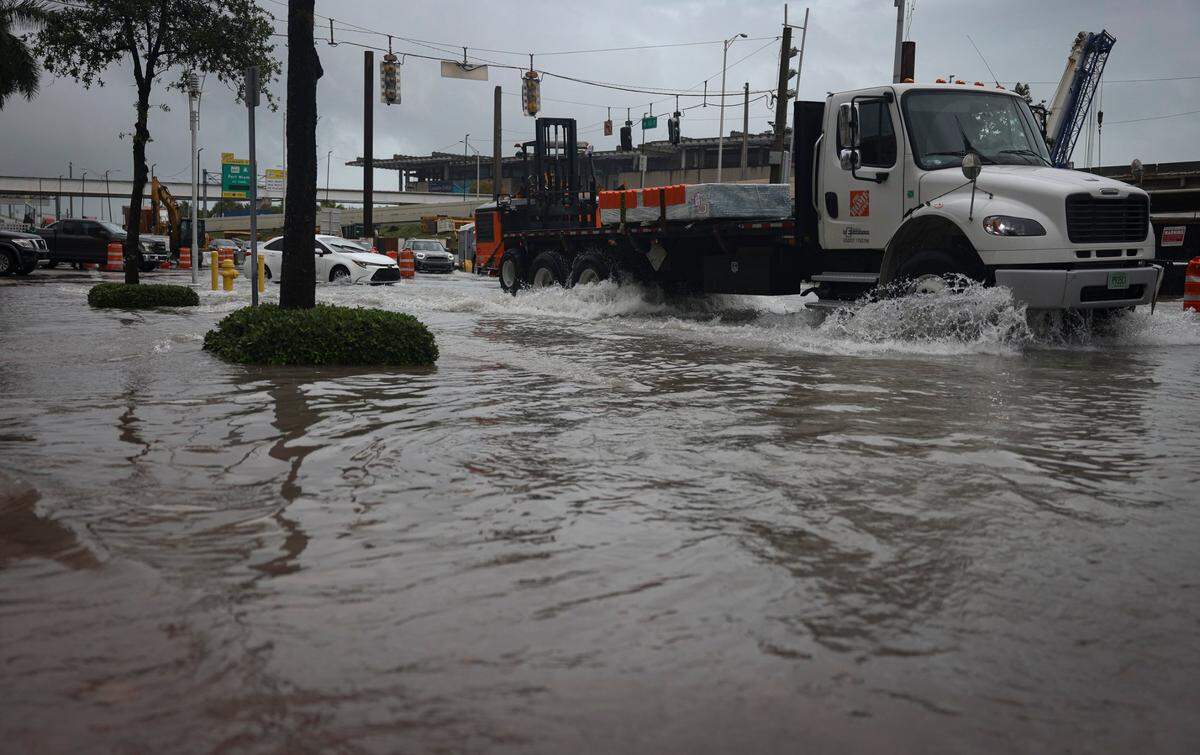 Exit 2 off of the MacArthur Causeway floods over the road and onto the sidewalk during a rain storm on Wednesday, April 12, 2023, in Miami.