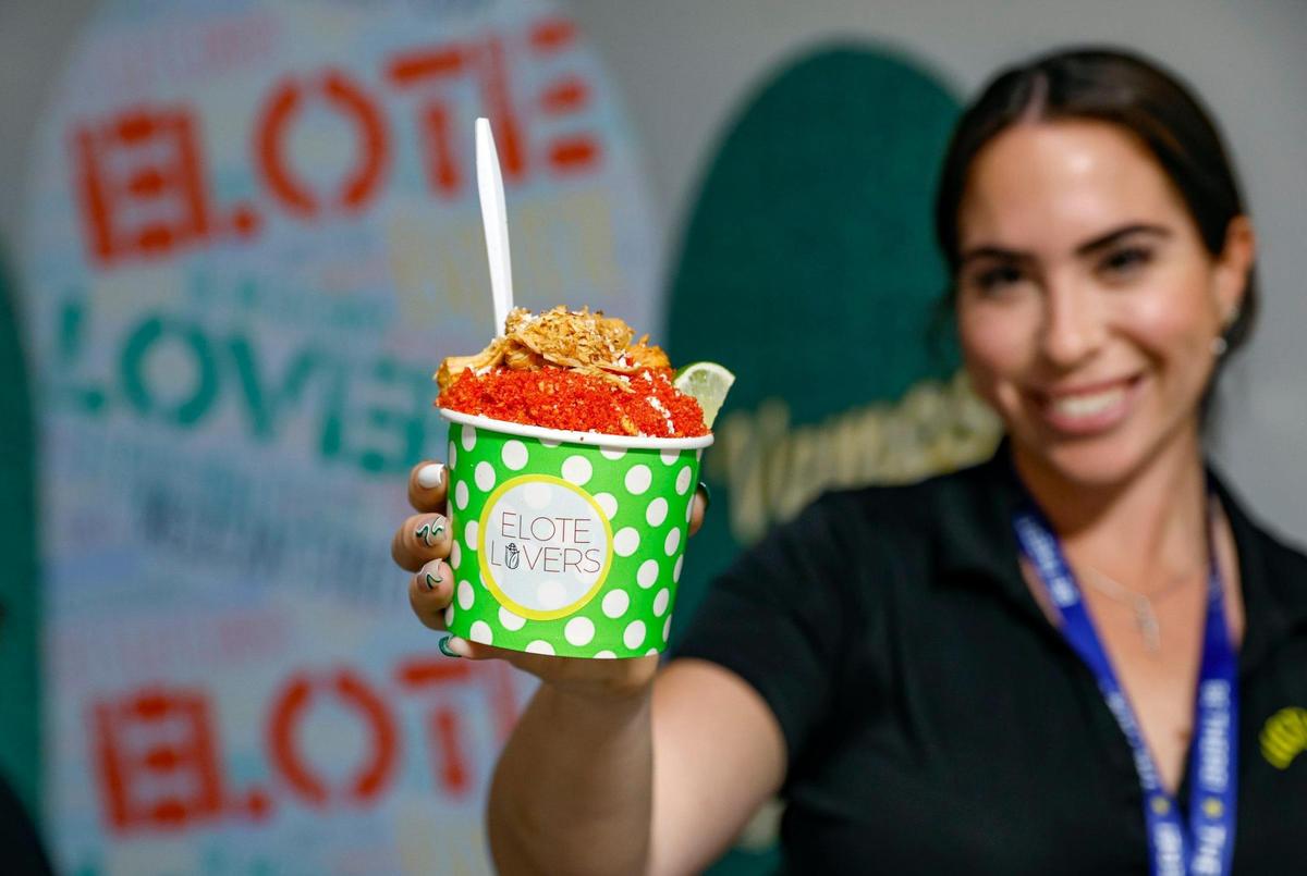 Ashley Larzabal offers up a chicken Elote En Vaso with hot fries during the opening day of the Miami-Dade County Fair & Exposition.