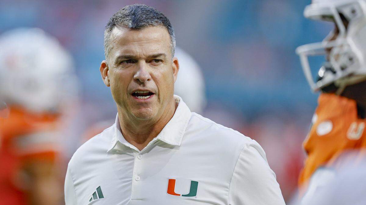 Miami Hurricanes head coach Mario Cristobal on the field for the start of the NCAA football game against the Louisville Cardinals at Hard Rock Stadium in Miami Gardens, Florida, on Friday, October 17, 2025.